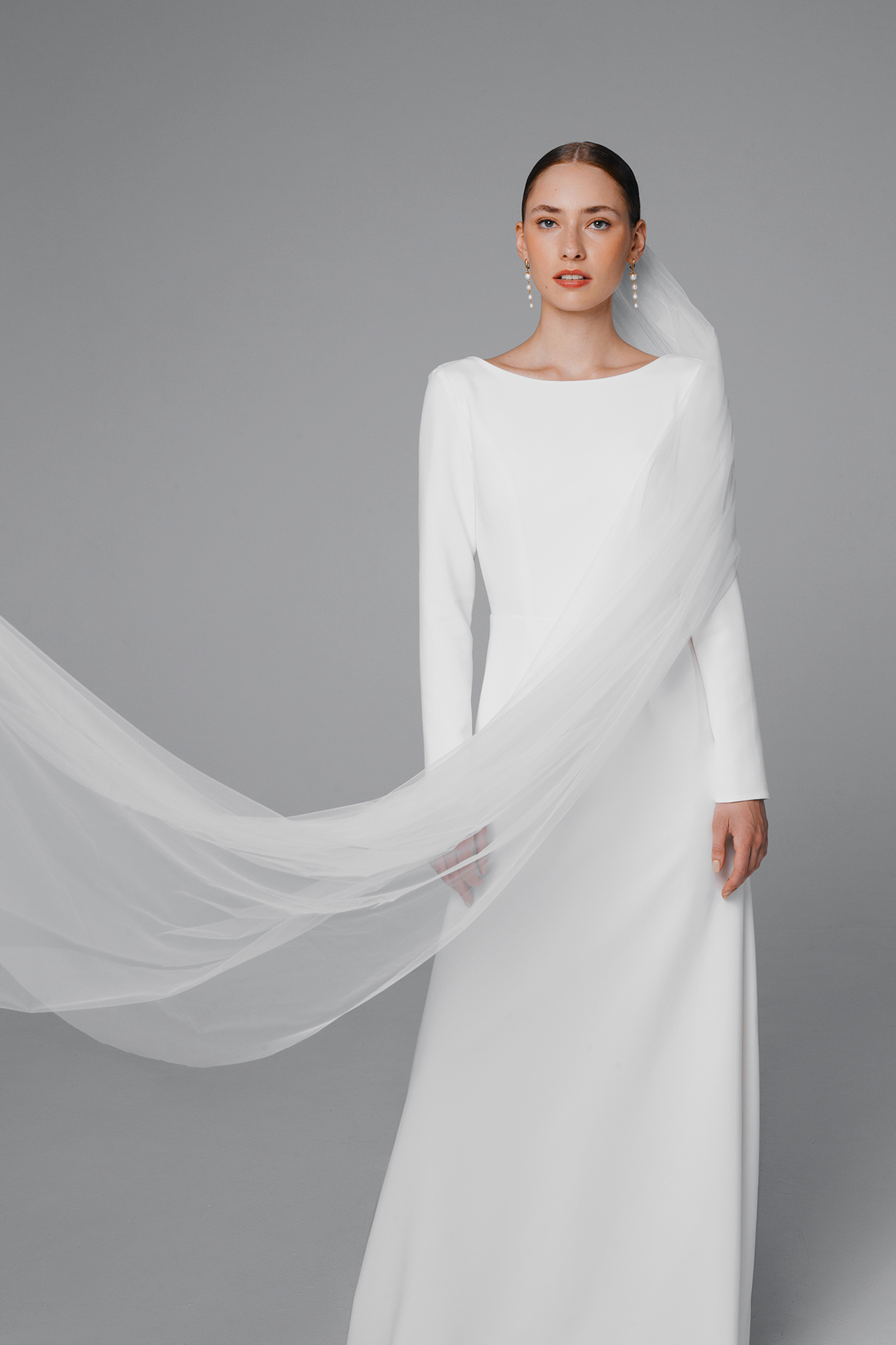 Fit and flare wedding dress with low back and long sleeves.