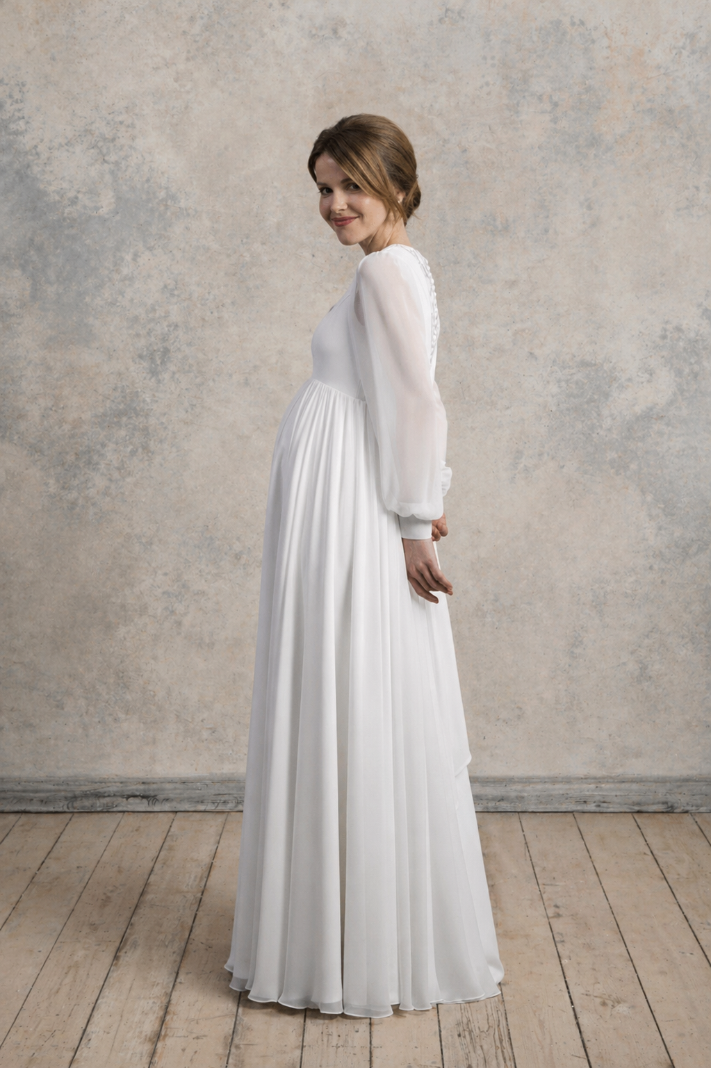 Side view of a maternity chiffon gown with long sleeves and a flowing A-line silhouette.
