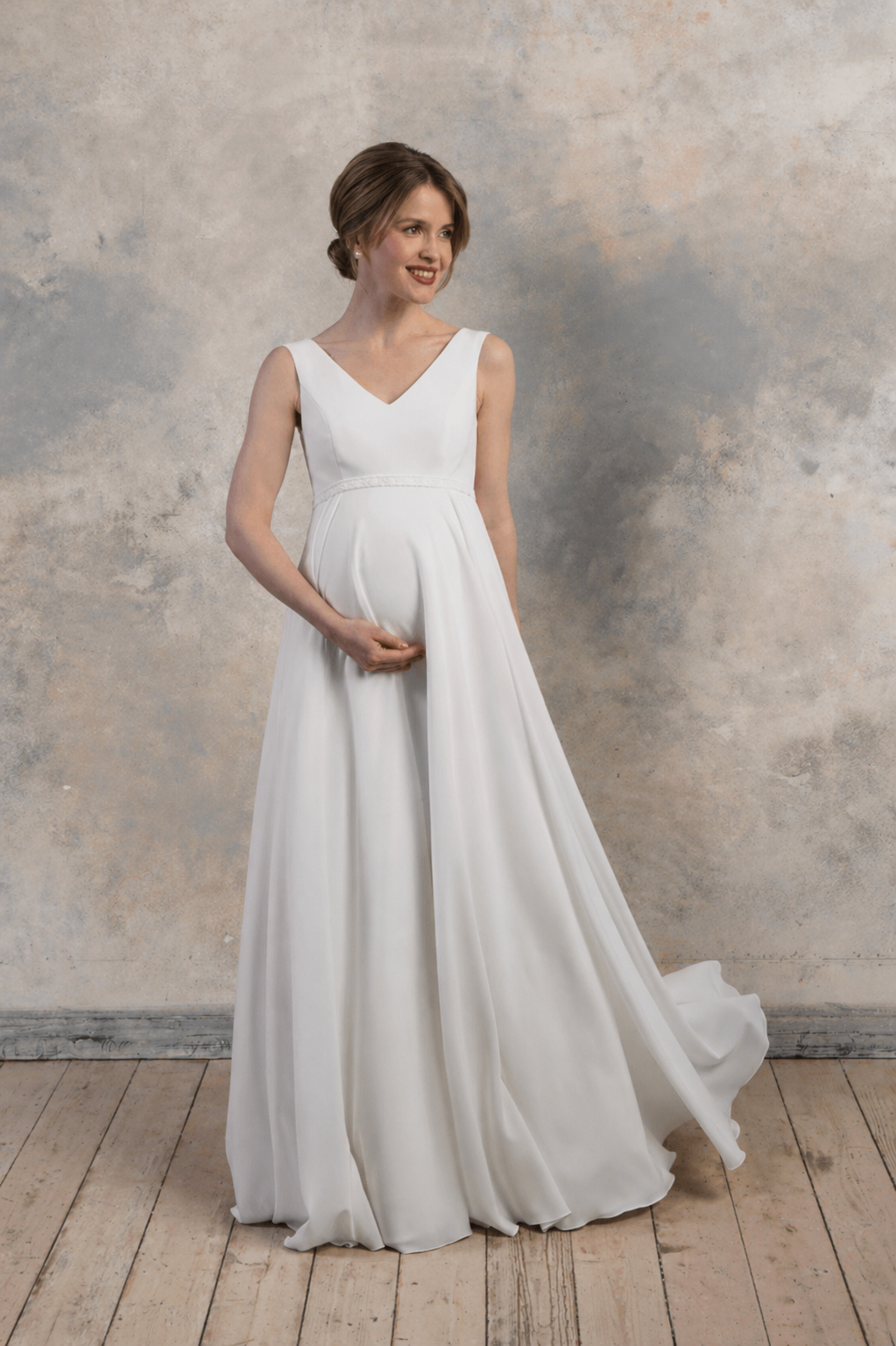 Front view of a maternity gown with a V-neckline and flowing crepe chiffon skirt.