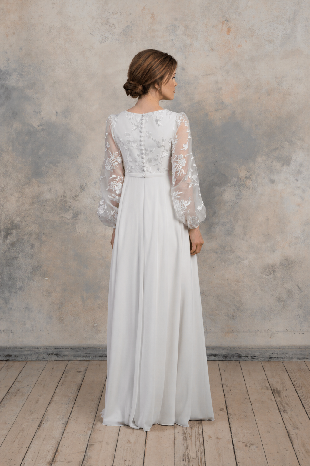 Back view of a maternity gown with lace sleeves and embroidered detailing.