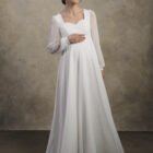 Front view of a maternity chiffon gown with long sheer sleeves and a soft sweetheart neckline.