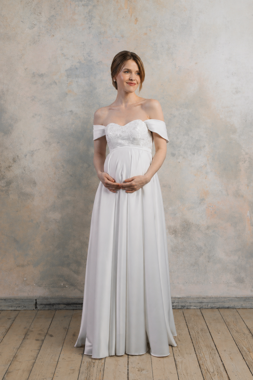 Full front view of off-the-shoulder maternity wedding dress with sweetheart neckline and flowing skirt