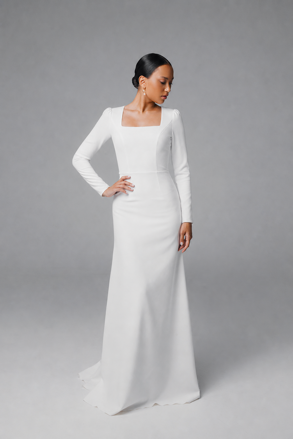 Simple white bridal gown with long sleeves and elegant back buttons