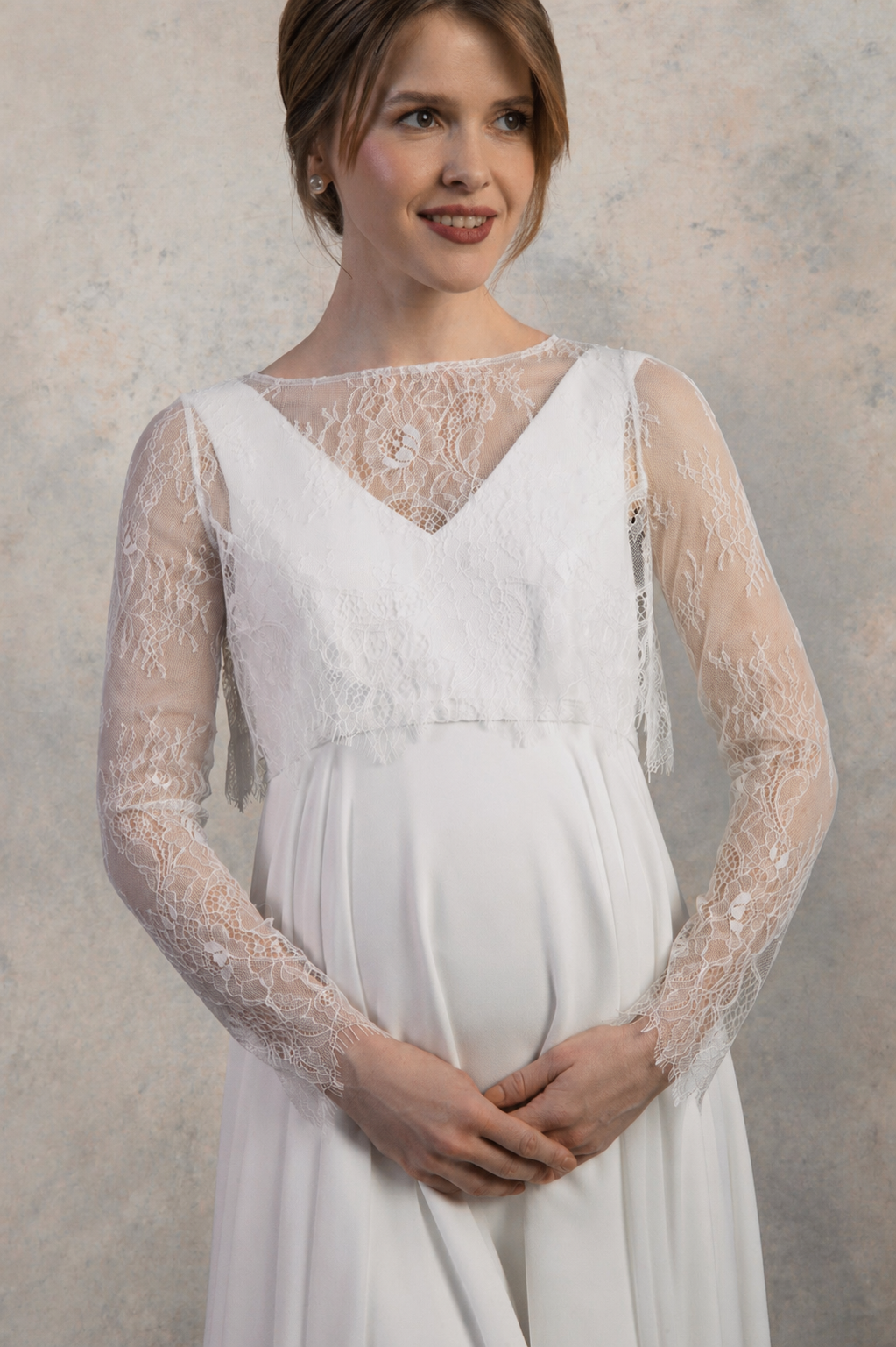 Close-up of a maternity gown with sheer lace sleeves and layered V-neck detailing.