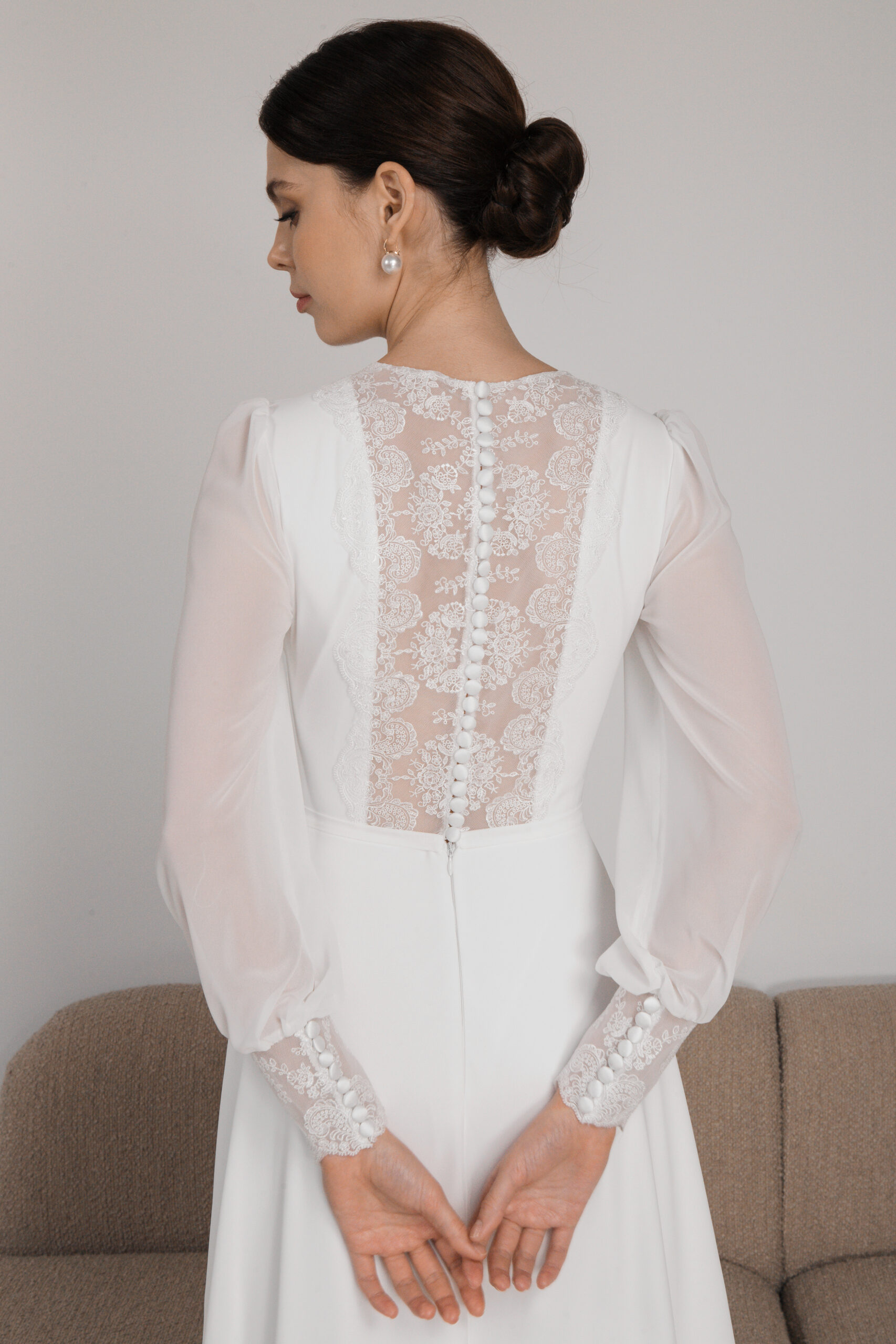 Sheer lace panel with covered buttons on white wedding dress