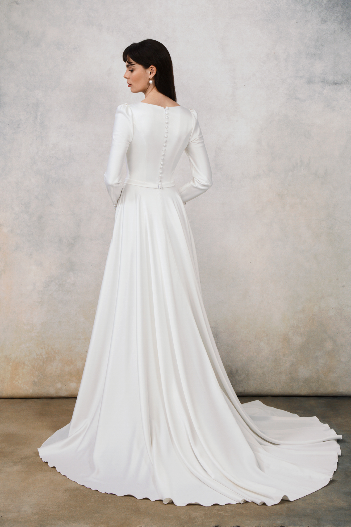 Back view of satin wedding gown with button-down closure and train