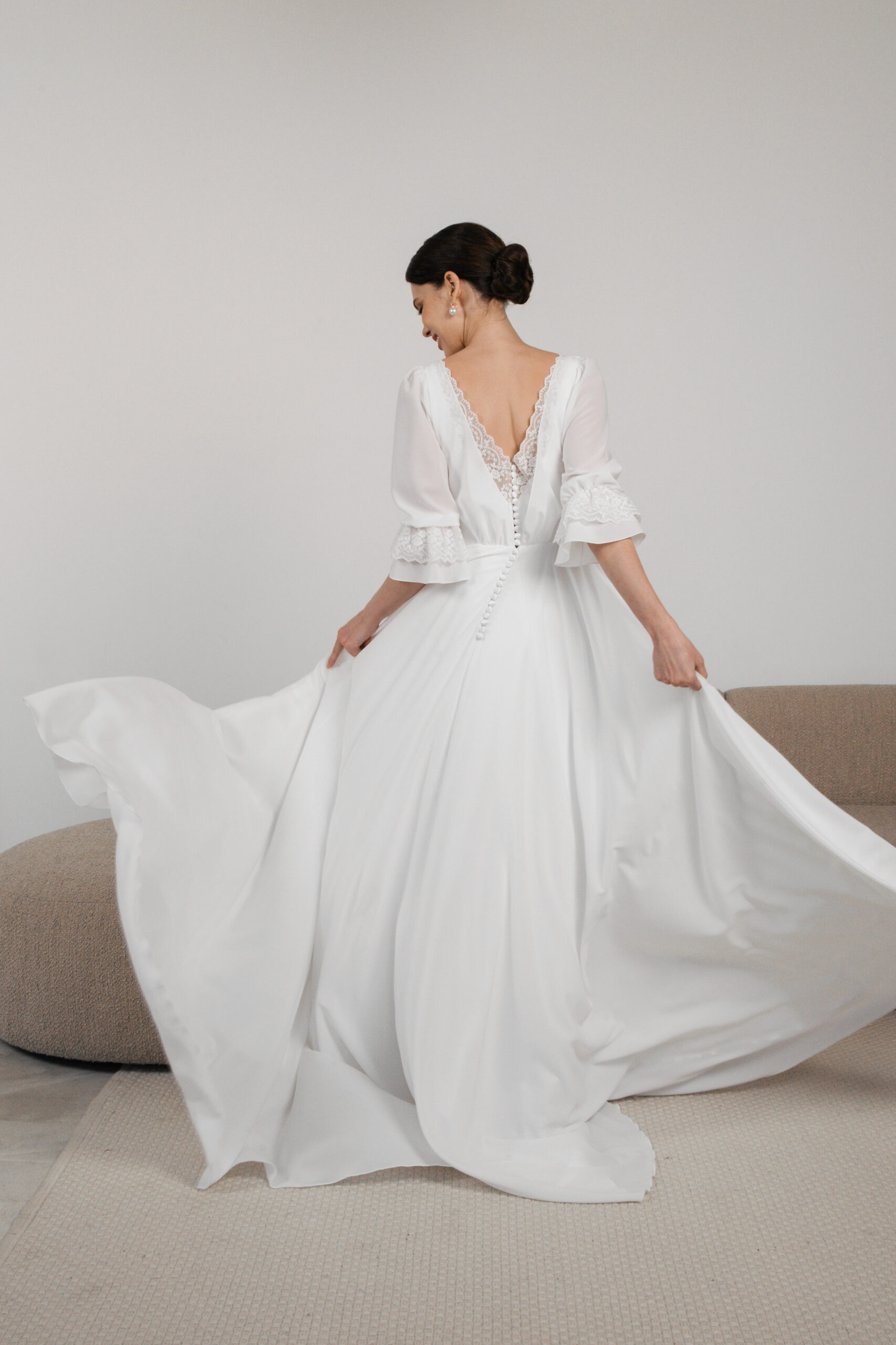 Flowing modest wedding dress with lace cuffs and open back
