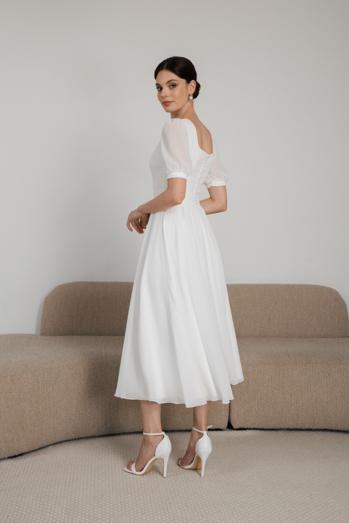 Side view of modest tea-length dress with puff sleeves