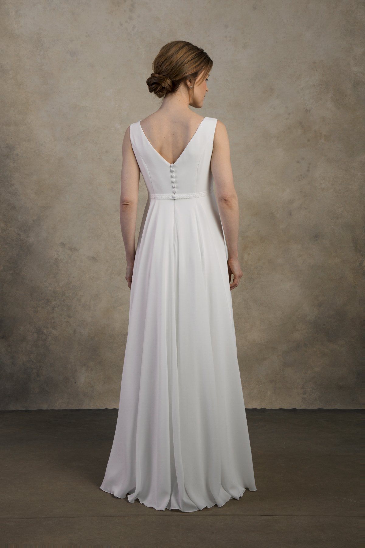 Full back view of a maternity chiffon gown with a V-back and flowing A-line skirt.