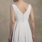 Close-up back view of a maternity gown with a deep V-back and covered buttons.