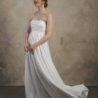 Strapless maternity gown with a softly draped bodice and a flowing skirt.
