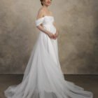 Maternity gown with a detachable train, strapless neckline, and softly draped skirt.
