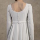 Close-up back view of a long-sleeve maternity gown with a deep scoop back and covered buttons.