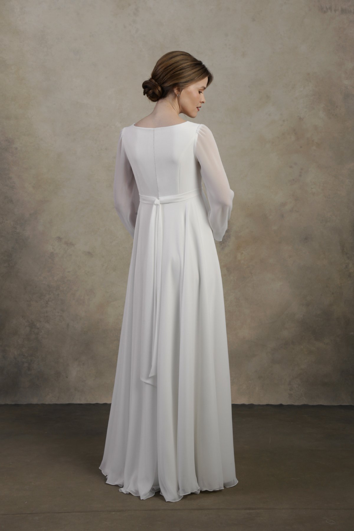 Maternity gown with long sleeves, an empire waist, and a softly flowing A-line skirt.