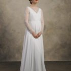 Front view of a maternity gown with lace sleeves and a V-neck layered bodice.