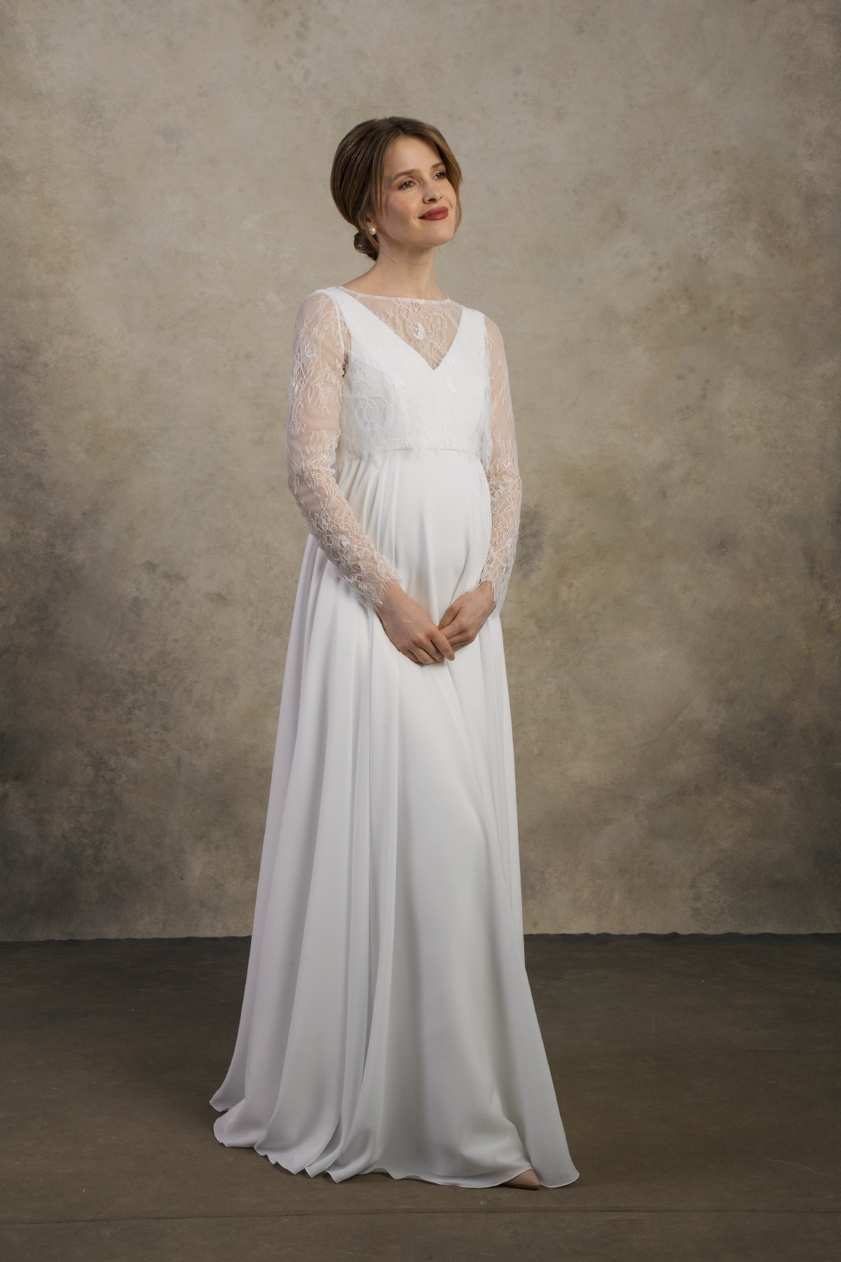 Front view of a maternity gown with lace sleeves and a V-neck layered bodice.