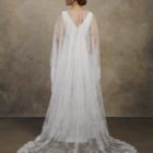 Back view of a maternity gown with a lace cape, long train, and V-back.