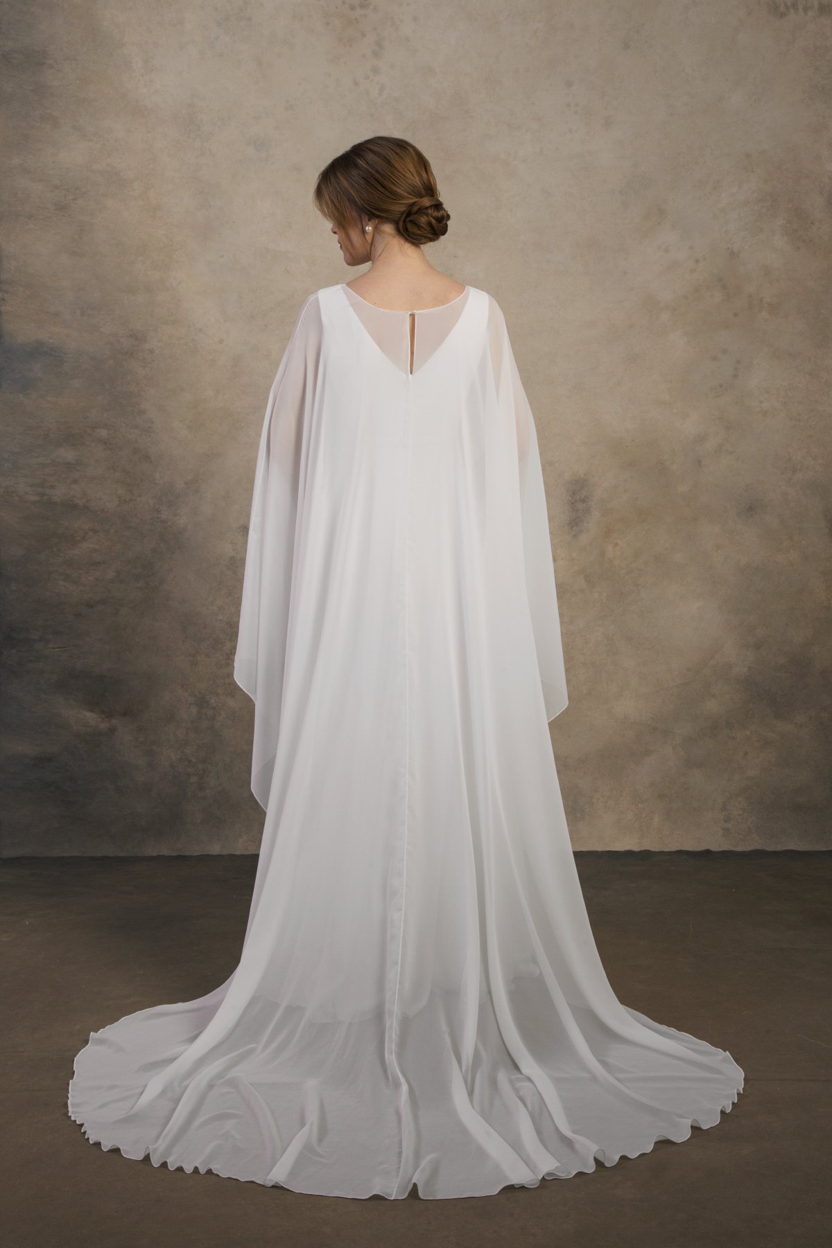 Back view of a maternity gown with a long flowing chiffon cape and V-back.