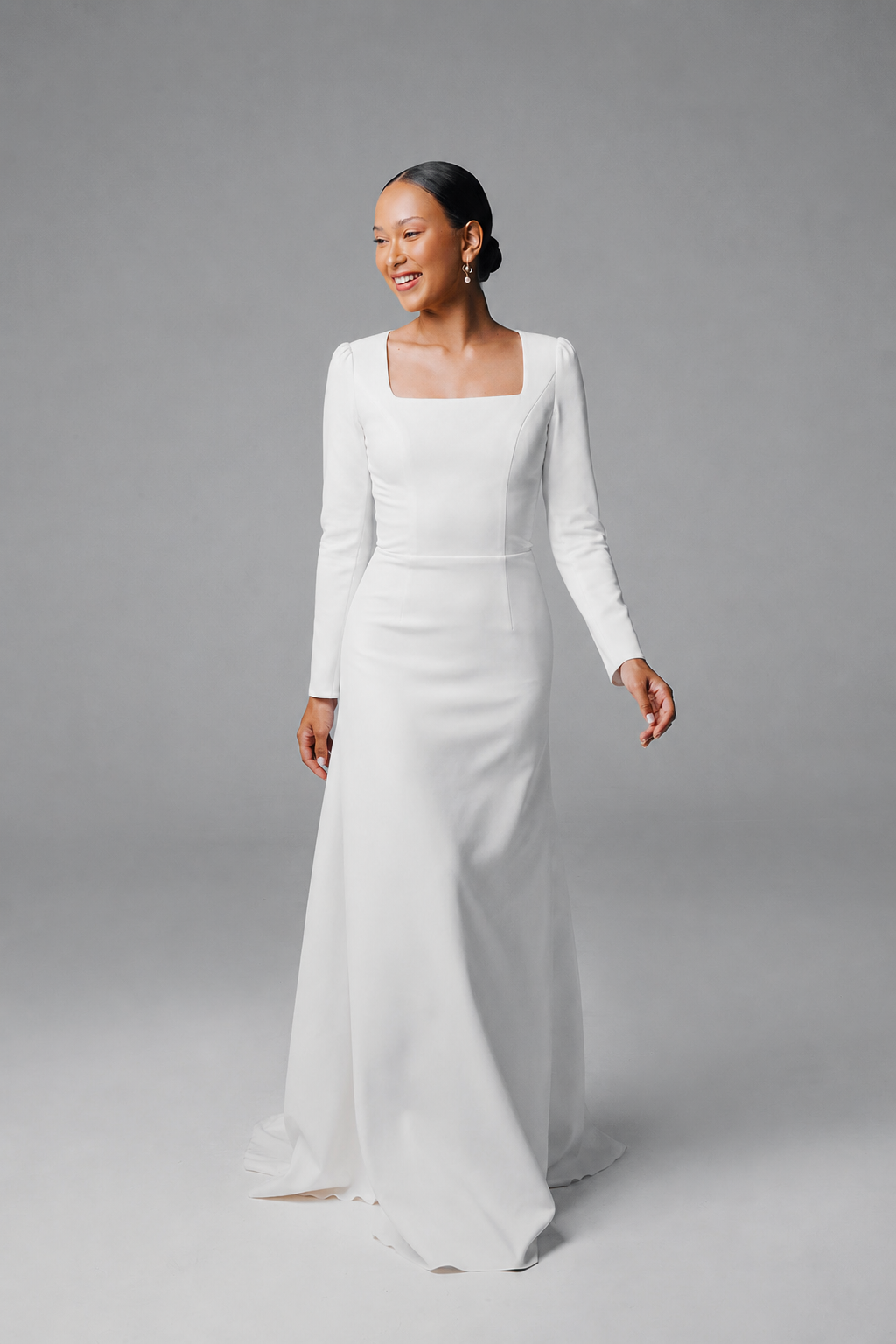 Simple white bridal gown with long sleeves and elegant back buttons